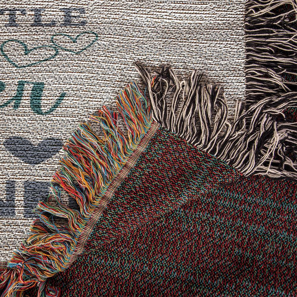 The Heirloom Artwork Woven Blanket is shown seen up close to show the texture of both sides of the blanket.