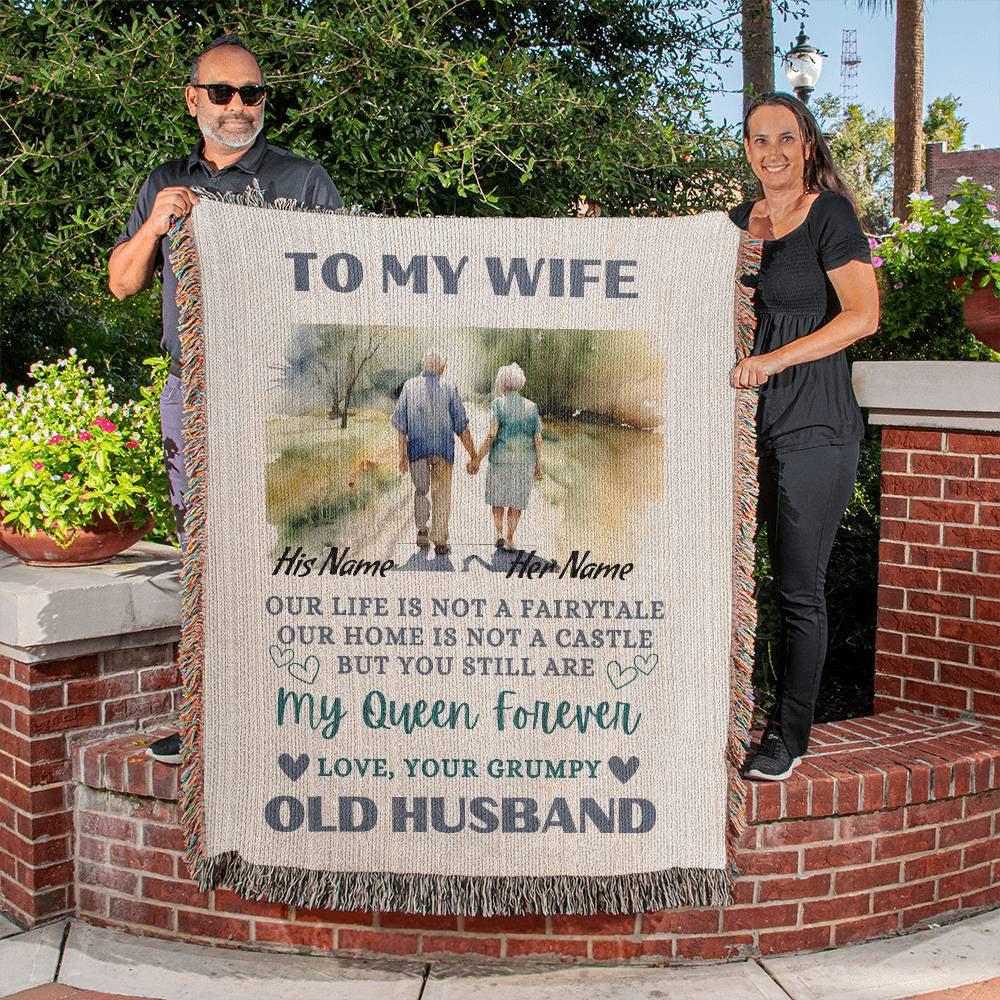 Heirloom Artwork Woven Blanket with a sentalmental message to a Wife from Her Husband being held up by a middle aged couple. 
